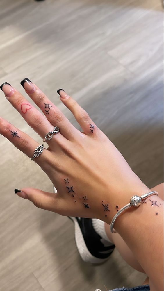 Tatouage Coeur Rouge Et étoiles Noirs Sur Le Doigt