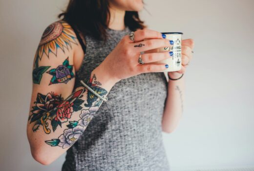 Bras entièrement tatoué en style old school coloré : tournesol, rose et pivoines